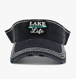 A black visor with stylish distressed detailing and a vibrant teal "Lake Life" embroidered patch centered on the front, representing a love for the tranquil lake atmosphere.