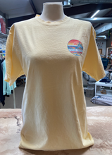 Load image into Gallery viewer, Front view of a butter-yellow ringspun cotton t-shirt on a mannequin, featuring a small &#39;Cedar Creek Lake Life&#39; logo on the left chest area, in a store environment.