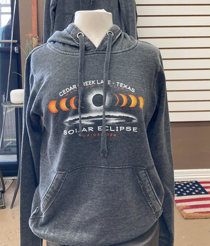 A mannequin wears a charcoal gray fleece hoodie featuring a solar eclipse graphic with phases of the moon and 