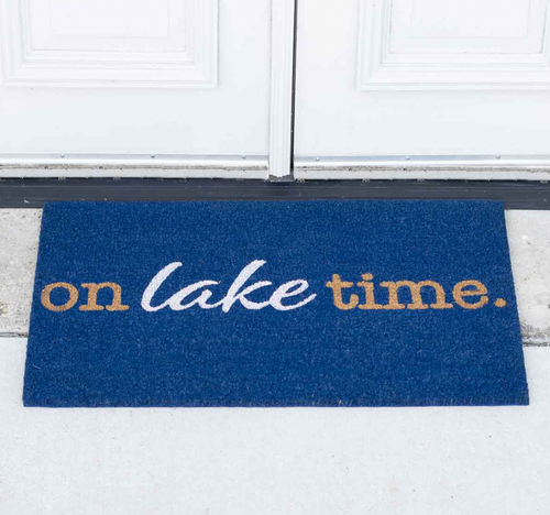 A blue coir doormat placed in front of a white door, with the phrase 