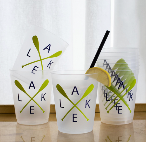 A stack of translucent plastic cups with a design featuring crossed oars in green and the word 