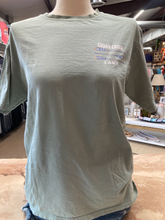 Load image into Gallery viewer, The front of a sage green, short-sleeved t-shirt displayed on a mannequin. A small, faded graphic of crossed canoe paddles with stars and stripes sits on the left chest area, with &quot;CEDAR CREEK LAKE&quot; printed above and below in a semicircle.