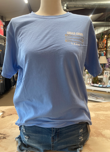 The front of a heather green ringspun cotton t-shirt on a mannequin, with the 'CEDAR CREEK LAKE' text displayed on the upper left chest area in a modest font size.