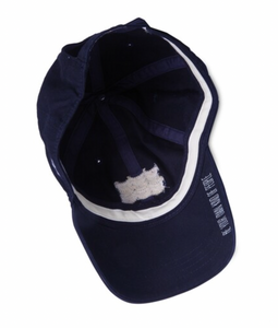 The inside view of a navy baseball cap showing the sweatband and a tag with care instructions, emphasizing the hat's well-crafted interior and comfort design.